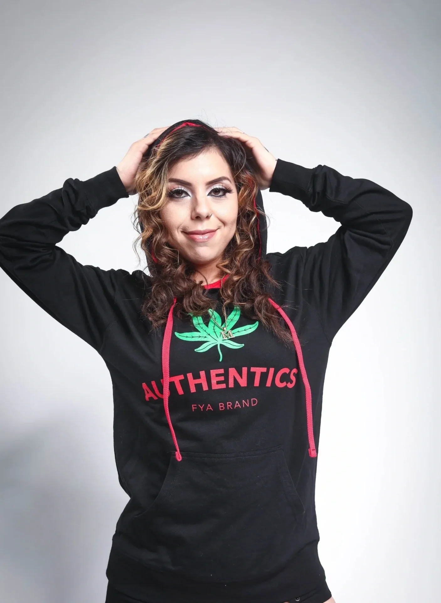 A woman wearing a black hoodie with a marijuana leaf on it.