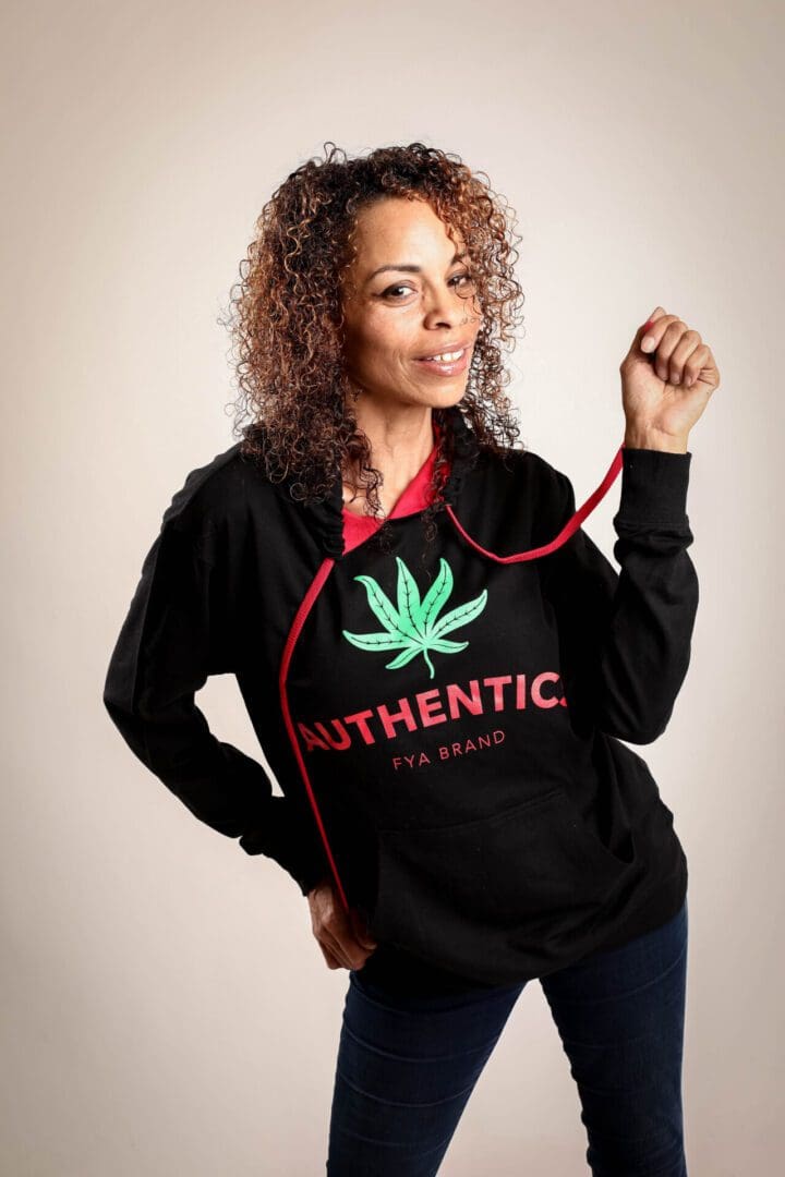 A woman holding onto a red cord with a marijuana leaf on it.