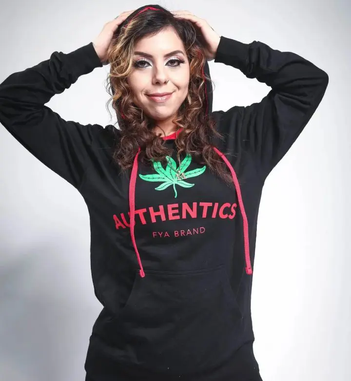 A woman wearing a black hoodie with a marijuana leaf on it.