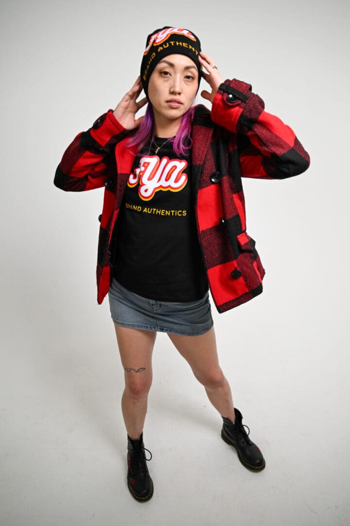 Fashionable person in a red plaid jacket and graphic tee.