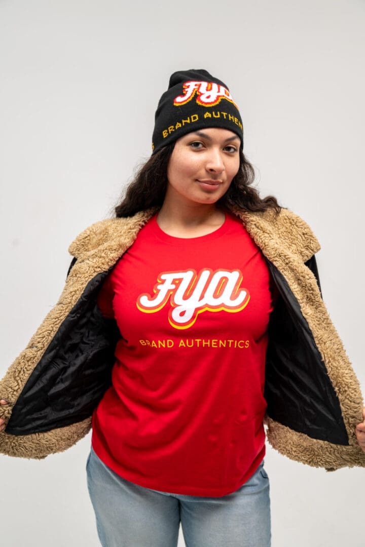 Woman in a red shirt and fur-lined jacket opening her coat.