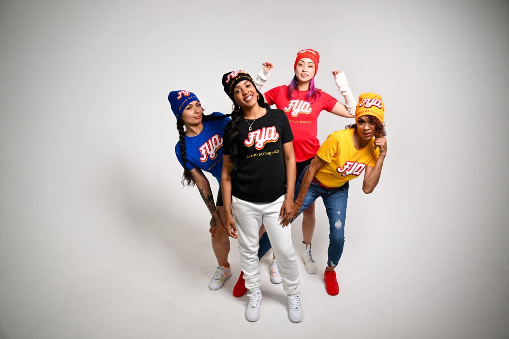 A group of five friends dressed in colorful outfits posing cheerfully.